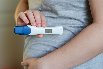 一位孕妇拿着数字妊娠测试阳性的近照