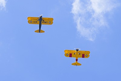 两架双翼飞机从头顶飞过。