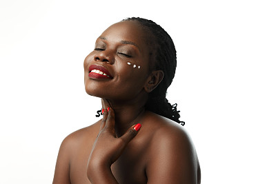 有机护肤品。阳性的非洲妇女使用面霜滋润皮肤隔离在白色的工作室背景