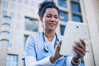 非洲女医生在户外使用数码平板电脑。
