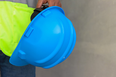 施工现场工程师手持蓝色防护安全安全帽头盔，避免事故发生。