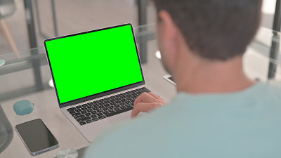 男子工作在笔记本电脑与绿屏色度键
