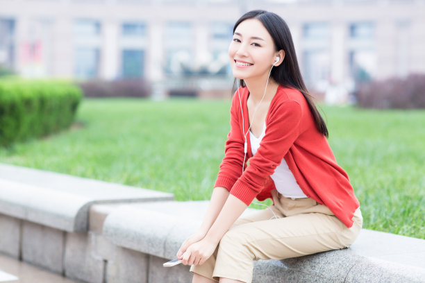 年轻女孩用智能手机的耳机听音乐