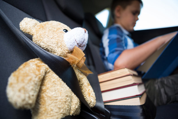 一个十几岁的男孩在车里看书