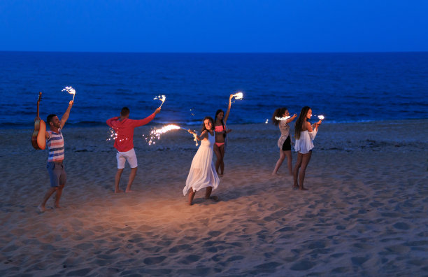 朋友们在海滩上举着火把跳舞庆祝