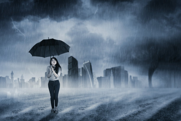 撑着伞站在雨中谨慎——雷雨城市上空的闪电恶劣天气水滴的背景雨伞在