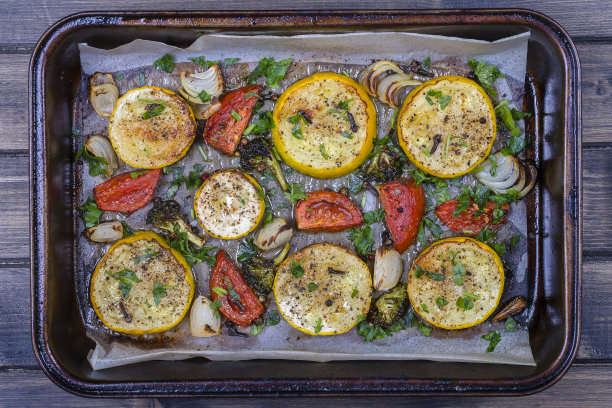 西葫芦，西红柿，花椰菜，洋葱和欧芹在烤箱里烤。俯视图