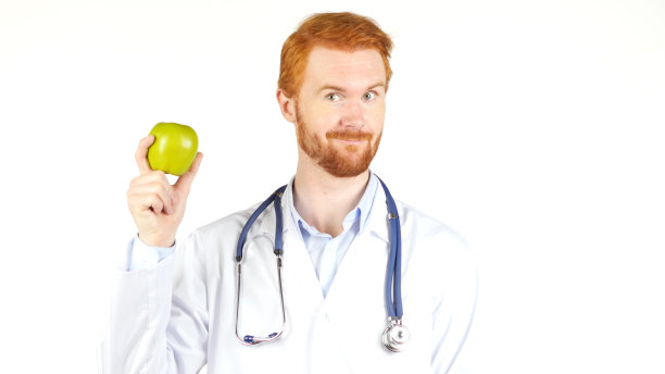 微笑的医生向镜头展示青苹果