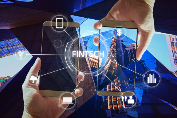 “金融科技”一词出现在数字虚拟屏幕上，背景是两个商人的手拿着智能手机。