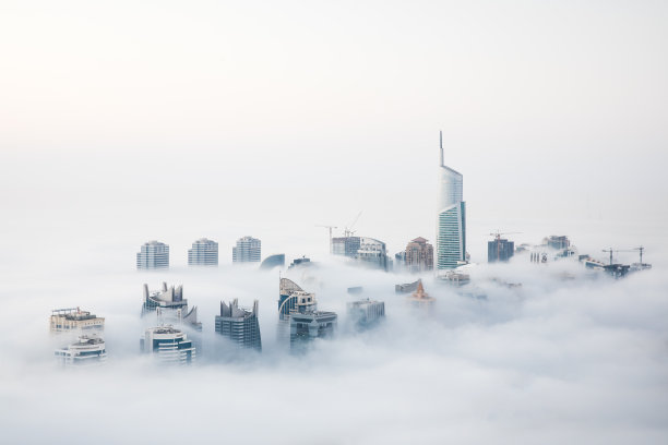 在冬天的早晨，摩天大楼被浓雾包围着。