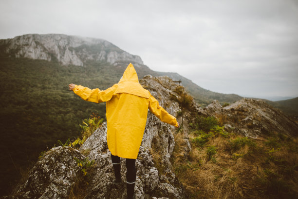 山顶上穿着黄色雨衣的女人