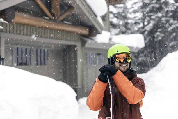 快乐的滑雪板戴头盔和护目镜在滑雪山