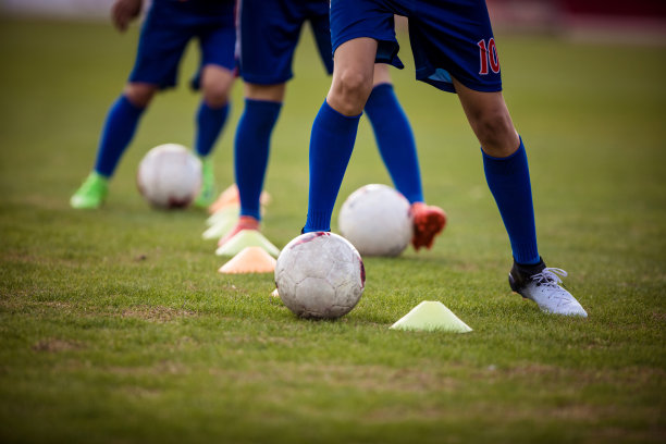在一项运动训练中,不认识的足球运动员在圆锥之间运球.