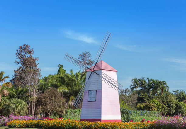 木制的粉色风车在公园的蓝天上