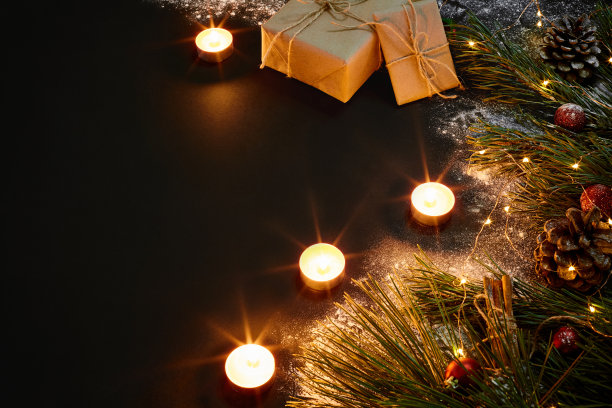 圣诞礼物，圣诞树，蜡烛，彩色装饰，星星，球在黑色的背景