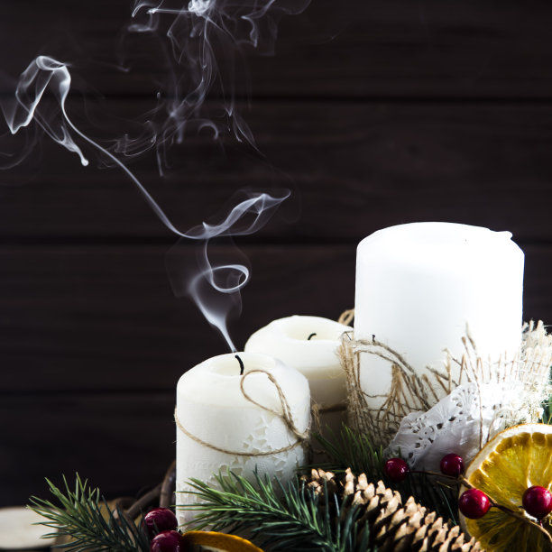 熄灭的白色蜡烛冒出的烟——用花环和树枝装饰的圣诞摆设.hygge概念