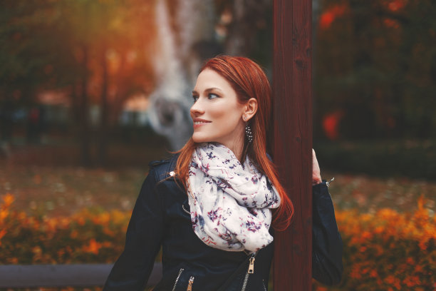 年轻时髦的红发女人看着别处的秋天