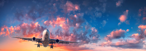 飞机和美丽的天空。在日出的蓝天上，有红、紫、橘色的云彩，有飞机景观。旅行。客运班机。商用飞机。私人飞机