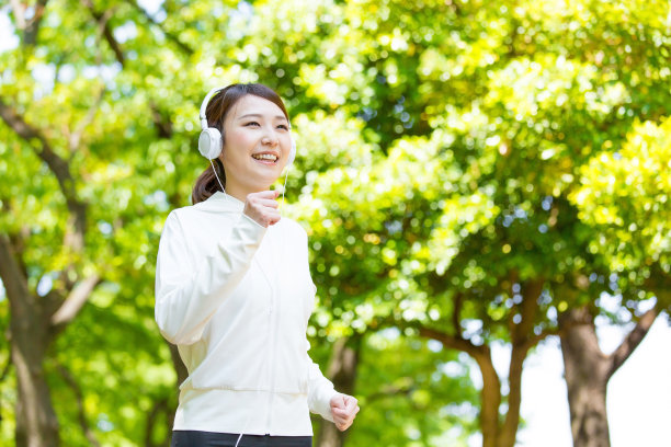 运动的亚洲女人在公园里跑步