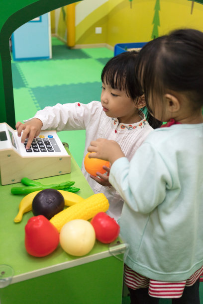 亚洲华人小女孩在水果店角色扮演