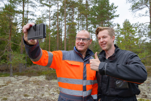 一个成熟的男人和一个年轻的男人一起在森林里工作