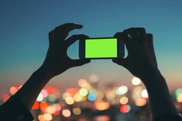女性用智能手机从个人角度拍摄散焦的城市景观