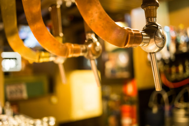 啤酒酒吧酒吧水龙头，柜台与模糊的酒吧背景。布鲁塞尔比利时