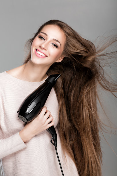 用吹风机吹头发的女人