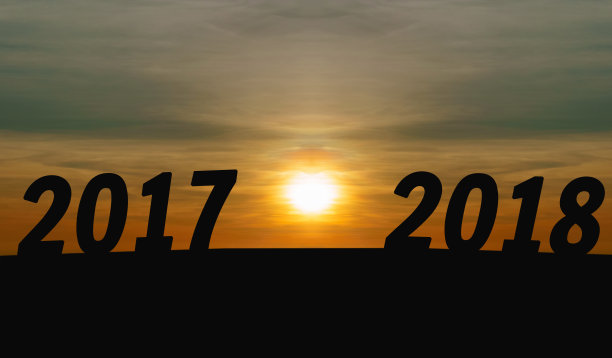 新年快乐概念。轮廓日出与字2017年至2018年在山上