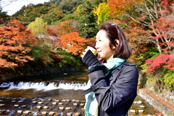 日本妇女在京都雅泽欣赏美丽的秋叶
