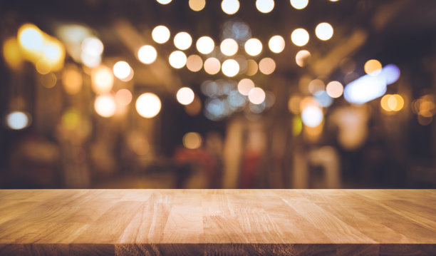 木条桌子与模糊的灯光在夜晚街头咖啡馆