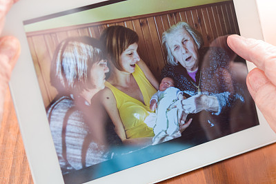 90多岁的曾祖母在数码平板电脑上看四代同堂的照片