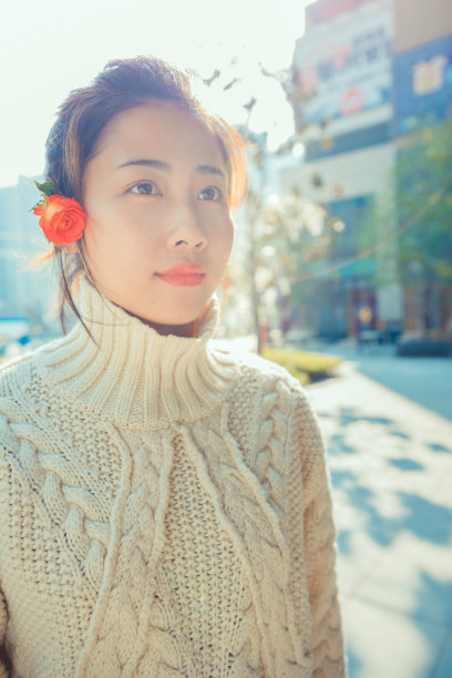 亚洲女孩在太阳耀斑下的红花，上海，中国