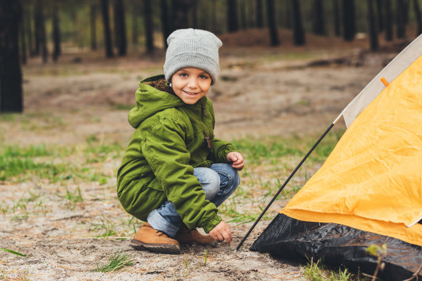 男孩坐在露营帐篷附近