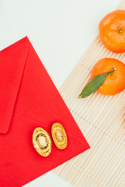 俯视图的红色信封有橘子和中国金元宝，中国新年的概念