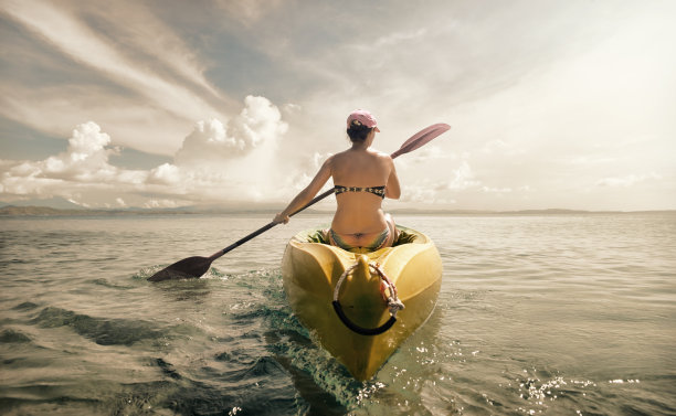 女人旅行者探索平静的热带海湾由皮艇。
