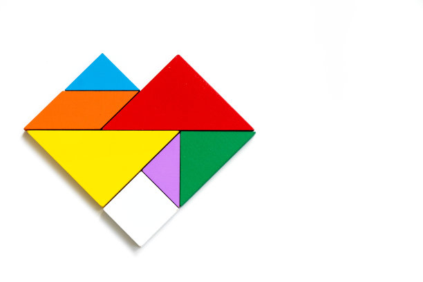 彩色木七巧板在白色的背景心形