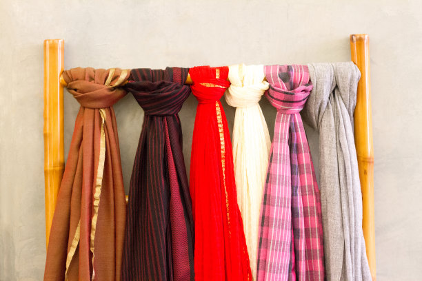 时尚:五彩缤纷的围巾挂在精品门外的梯子上