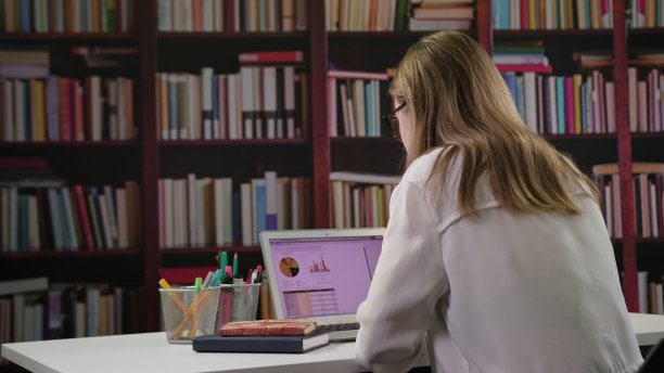 年轻女士在图书馆使用笔记本电脑