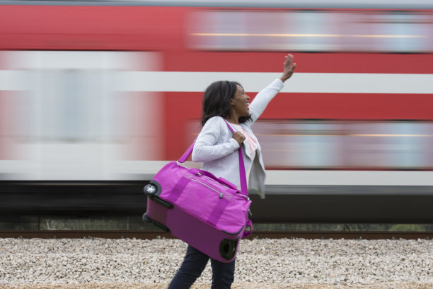 女游客向路过的火车挥手.