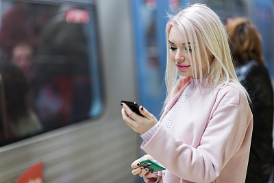 在地铁上使用智能手机的优雅女性