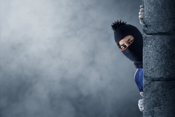 强盗躲在一堵空墙后面,墙上有文字