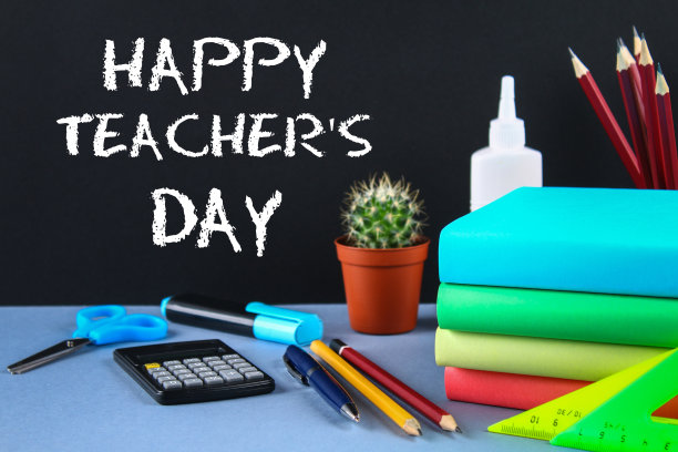 文字粉笔在黑板上:教师节快乐。学校用品，办公室，书籍，苹果。