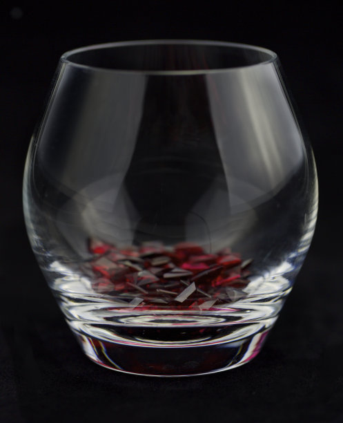 有趣的鸡尾酒-深红色宝石在玻璃上的黑色背景