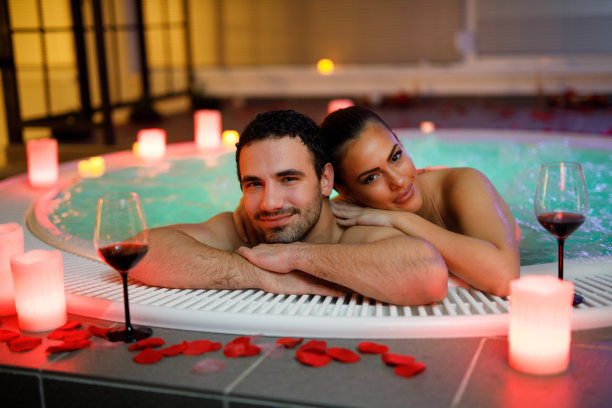 一对美丽的夫妇在健康水疗中心的热水浴缸里放松