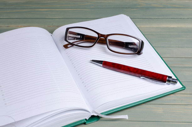 记事本，眼镜，钢笔，木制背景