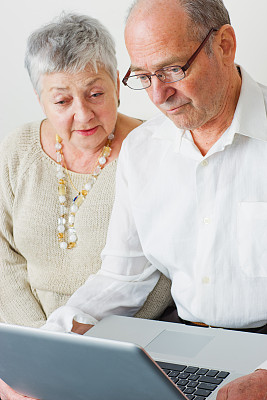 快乐的老年夫妇使用笔记本电脑