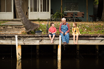 爷爷和曾孙、孙女在码头钓鱼