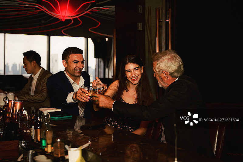 西装革履的商务人士在酒吧举杯庆祝友谊