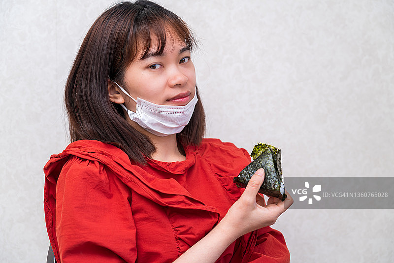年轻女子戴着口罩吃饭.新冠肺炎的新常态